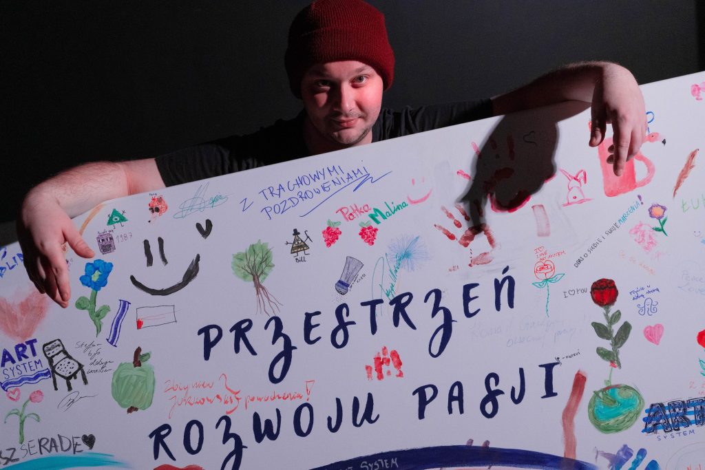 Na zdjęciu widoczny jest mężczyzna, Mateusz Piłat – prezes Fundacji ArtSystem.