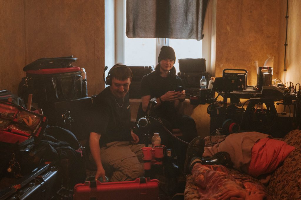 Studio System wygrywa. Dwóch mężczyzn trzymających telefony, jeden z nich uśmiecha się do osoby robiącej zdjęcie